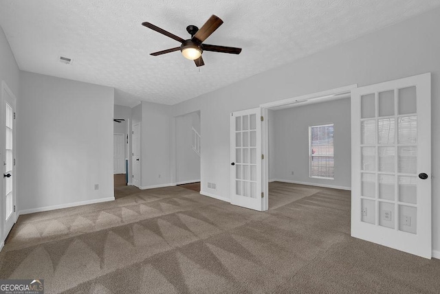 spare room with ceiling fan, carpet, a textured ceiling, and french doors