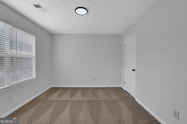 spare room with carpet floors and a textured ceiling