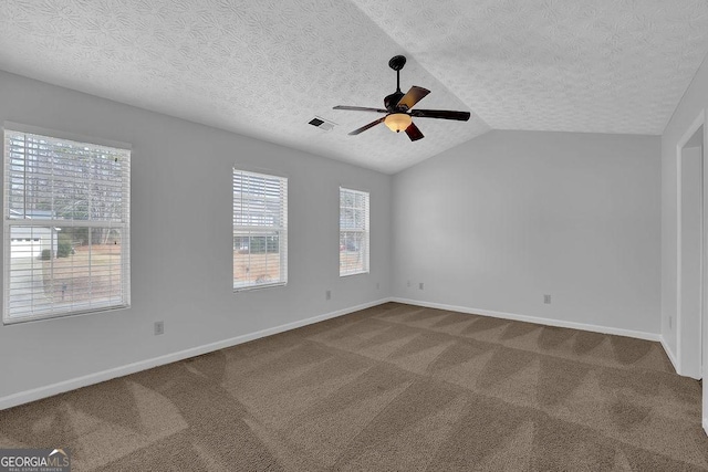 carpeted empty room with ceiling fan, lofted ceiling, and a textured ceiling