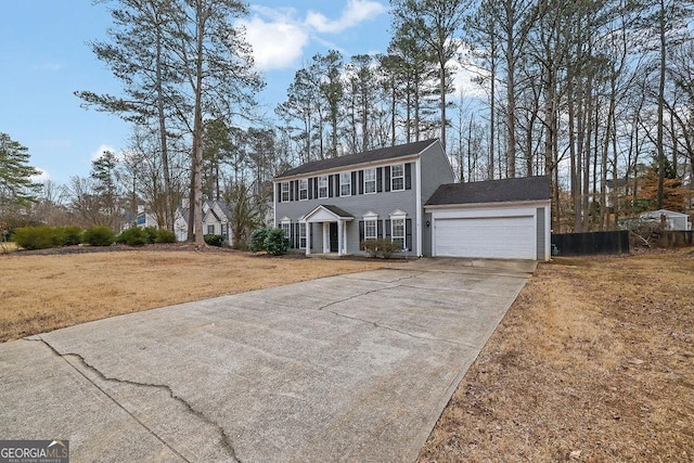 colonial inspired home featuring a garage and a front yard