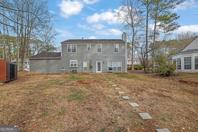 back of house featuring a lawn and central air condition unit