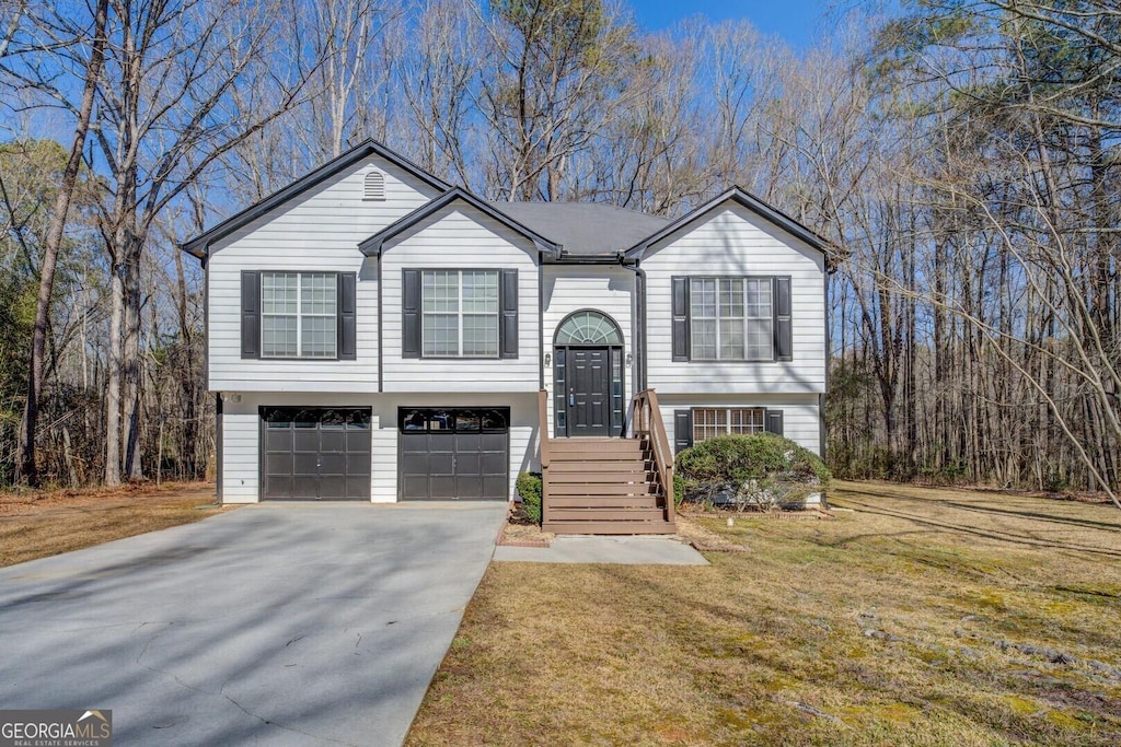 bi-level home featuring a garage and a front yard