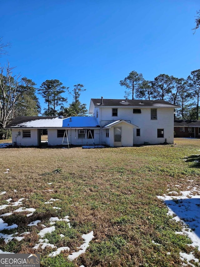 snow covered property with a lawn