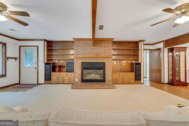 living room with built in shelves, ceiling fan, hardwood / wood-style floors, and a brick fireplace