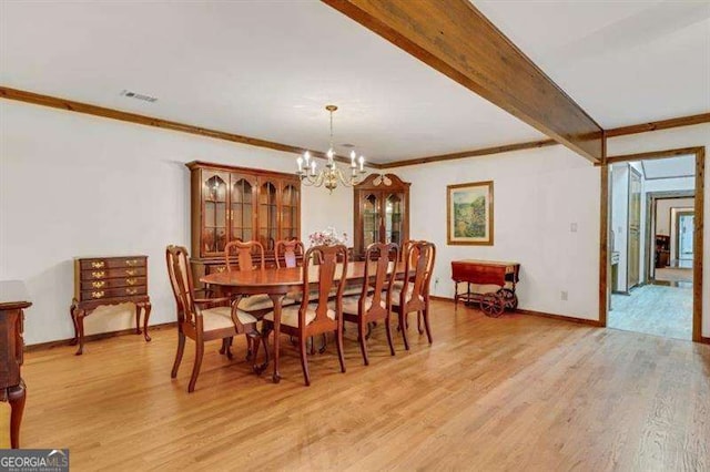 dining area with a notable chandelier, ornamental molding, and light hardwood / wood-style floors