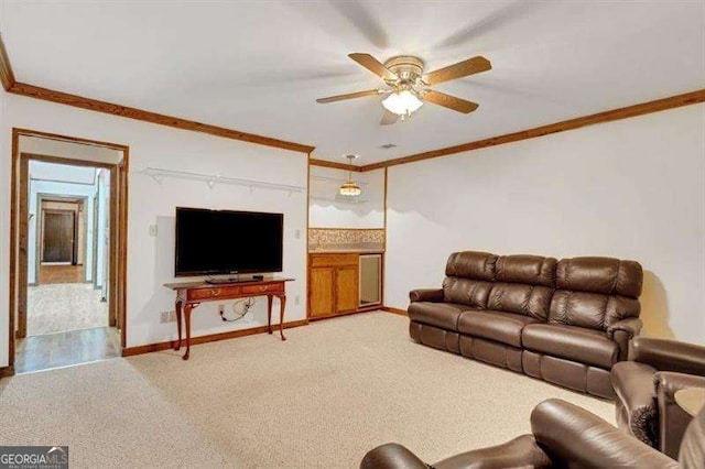 living room featuring crown molding, ceiling fan, and carpet