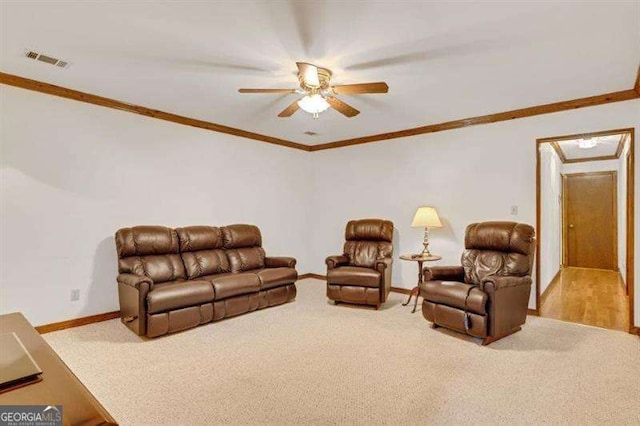 carpeted living room with ornamental molding and ceiling fan