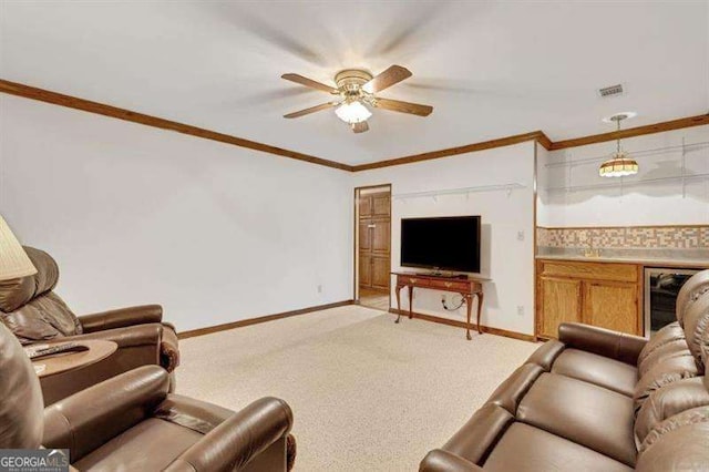 carpeted living room with ornamental molding, bar, beverage cooler, and ceiling fan