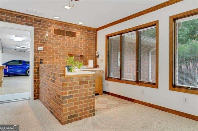 interior space with crown molding and brick wall