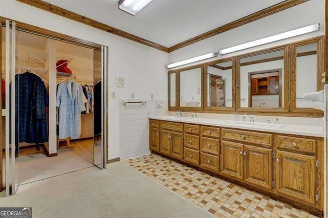 bathroom with tile walls, vanity, and crown molding