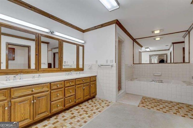 bathroom featuring tiled tub, crown molding, tile walls, tile patterned flooring, and vanity