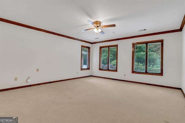 carpeted spare room with ceiling fan and ornamental molding