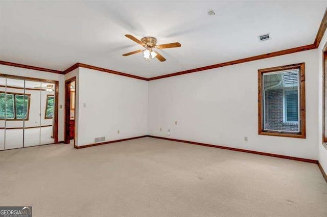 carpeted empty room featuring crown molding and ceiling fan