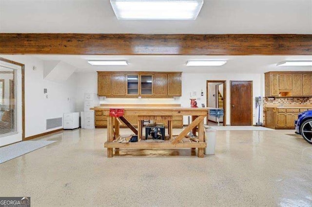 interior space featuring backsplash and beam ceiling