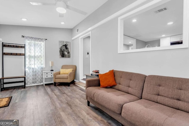 living room featuring wood-type flooring and ceiling fan