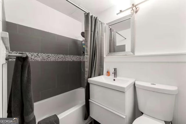 full bathroom featuring vanity, shower / tub combo with curtain, and toilet