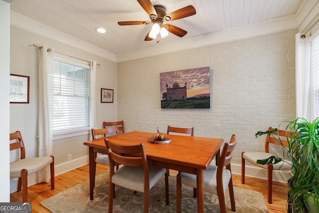 dining area with brick wall, a wealth of natural light, wooden ceiling, and light hardwood / wood-style flooring