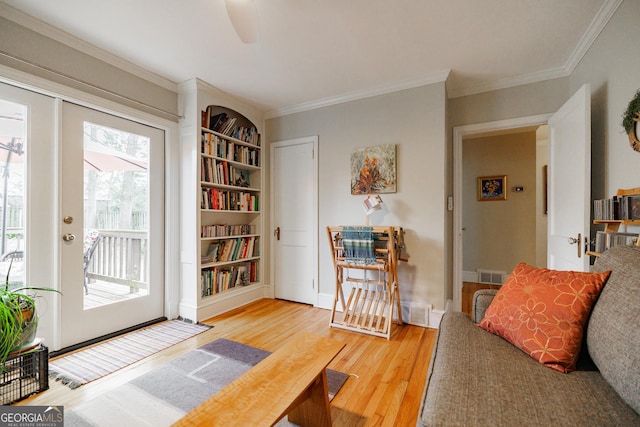 living area featuring crown molding and hardwood / wood-style floors