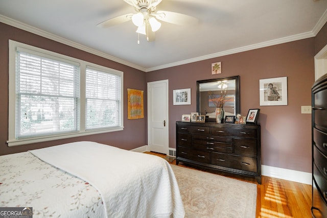 bedroom featuring ceiling fan, multiple windows, and light wood-type flooring