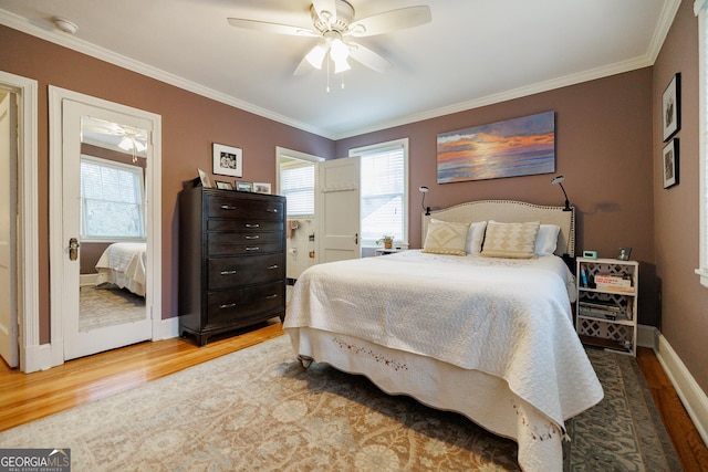 bedroom featuring wood-type flooring, ornamental molding, and ceiling fan