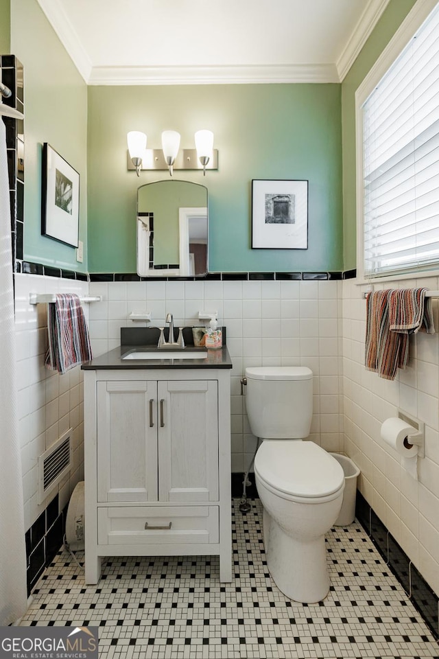 bathroom featuring tile walls, tile patterned flooring, vanity, toilet, and crown molding