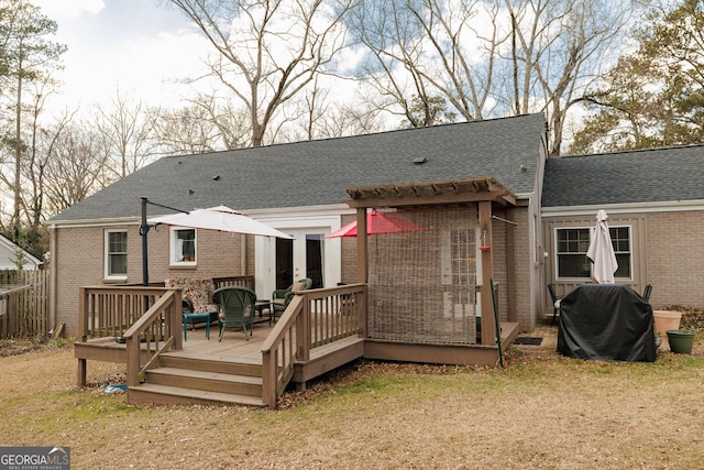 rear view of house with a yard and a deck