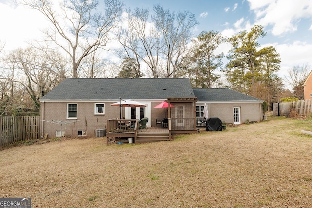 back of property with a lawn and a deck