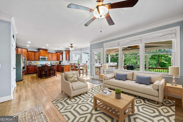 living room with crown molding, ceiling fan, and light wood-type flooring