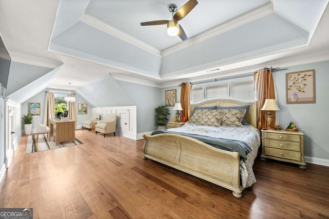 bedroom with lofted ceiling, crown molding, ceiling fan, wood-type flooring, and a raised ceiling