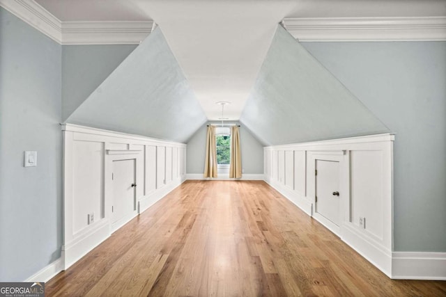 additional living space with hardwood / wood-style flooring and vaulted ceiling