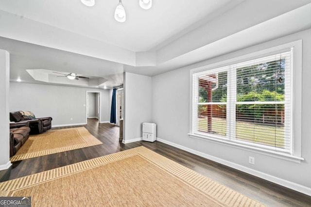 interior space featuring a tray ceiling, dark hardwood / wood-style floors, and ceiling fan