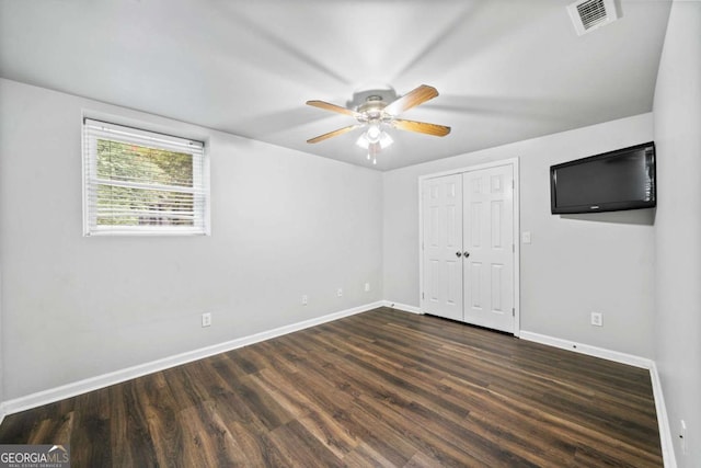 unfurnished bedroom featuring dark hardwood / wood-style flooring, a closet, and ceiling fan