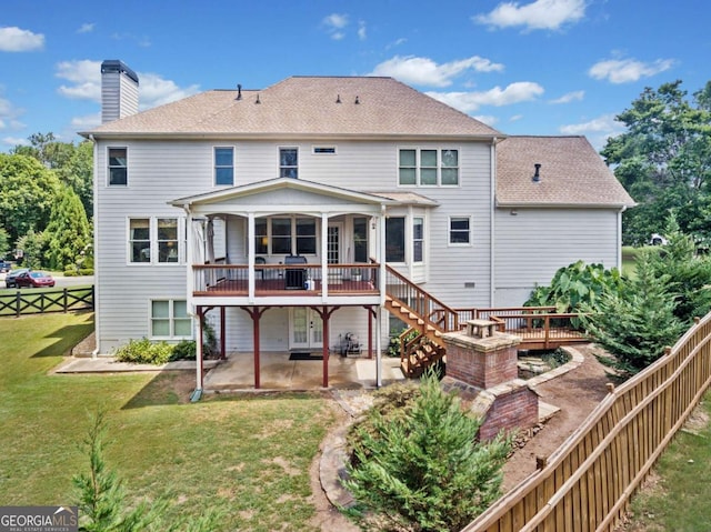 back of property with a yard, a deck, and a patio area