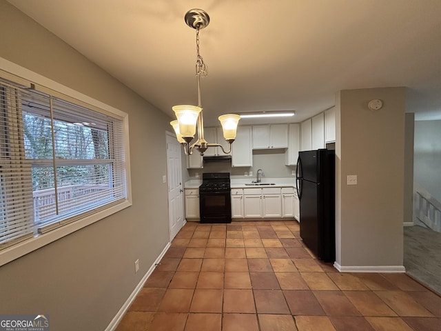 kitchen with sink, light tile patterned floors, white cabinetry, black appliances, and decorative light fixtures