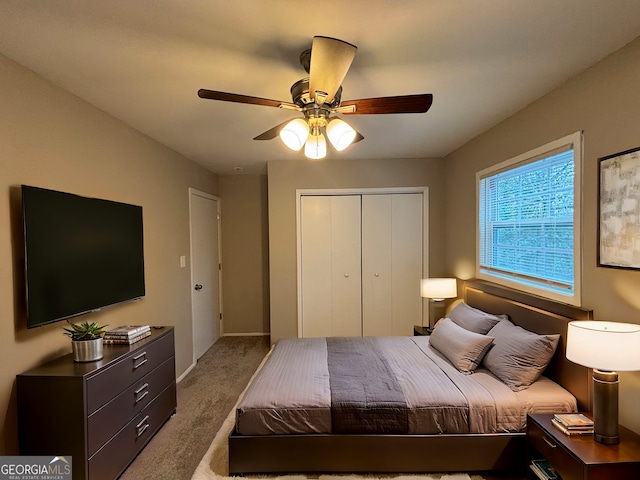 carpeted bedroom featuring ceiling fan and a closet