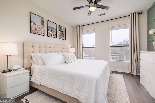 bedroom with dark hardwood / wood-style floors and ceiling fan