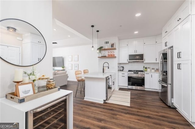 kitchen featuring white cabinetry, appliances with stainless steel finishes, a breakfast bar, and pendant lighting