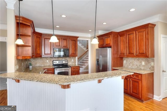 kitchen featuring stainless steel appliances, hanging light fixtures, a breakfast bar, and kitchen peninsula