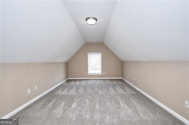 additional living space featuring lofted ceiling and light colored carpet