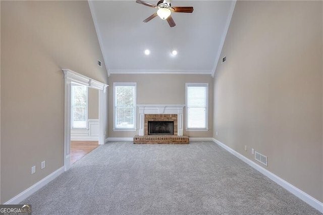 unfurnished living room featuring high vaulted ceiling, a fireplace, light colored carpet, ceiling fan, and crown molding