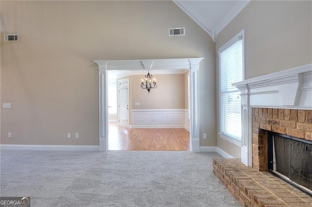 unfurnished living room featuring a fireplace, ornamental molding, a healthy amount of sunlight, light carpet, and vaulted ceiling