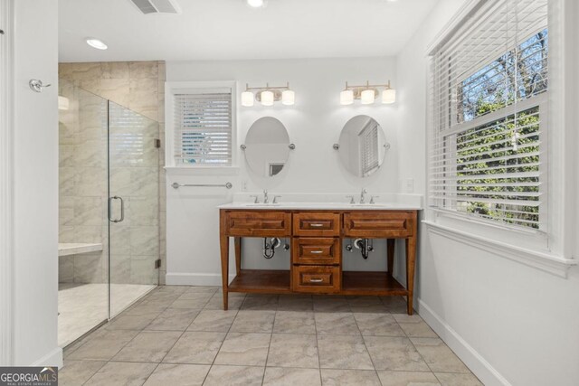 bathroom featuring a shower with door, vanity, and tile patterned floors