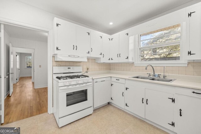 kitchen with white cabinetry, white appliances, and sink