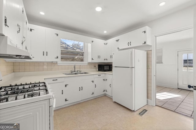 kitchen with a healthy amount of sunlight, sink, white cabinets, and white appliances