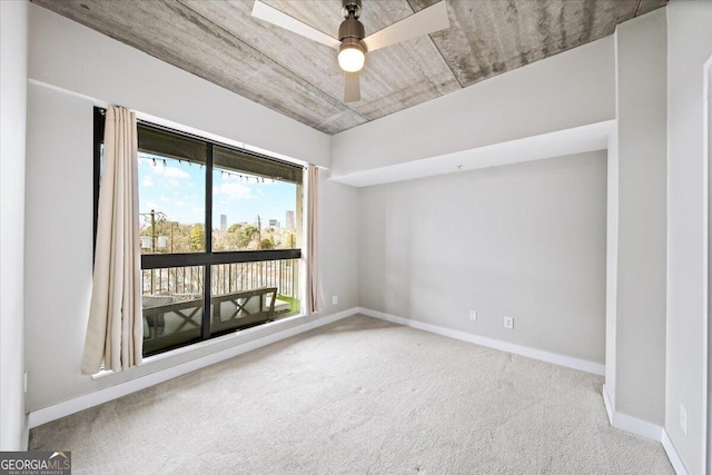 spare room with ceiling fan, carpet, and baseboards