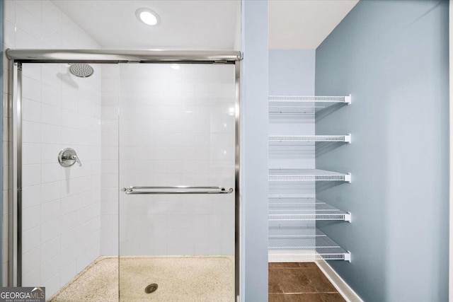 bathroom with a stall shower and baseboards