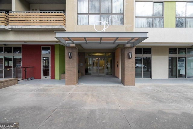 property entrance with brick siding and stucco siding