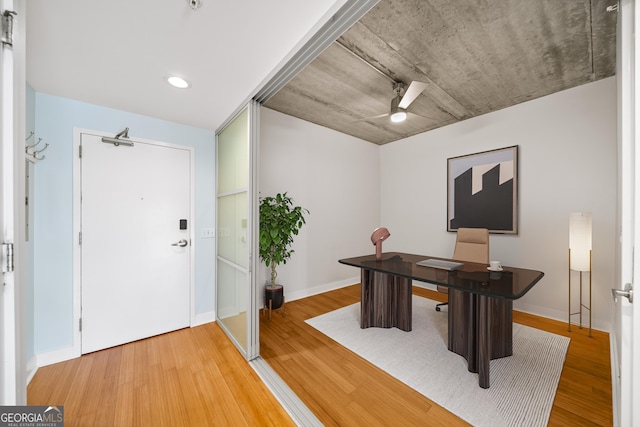 home office with light wood-type flooring, baseboards, and a ceiling fan