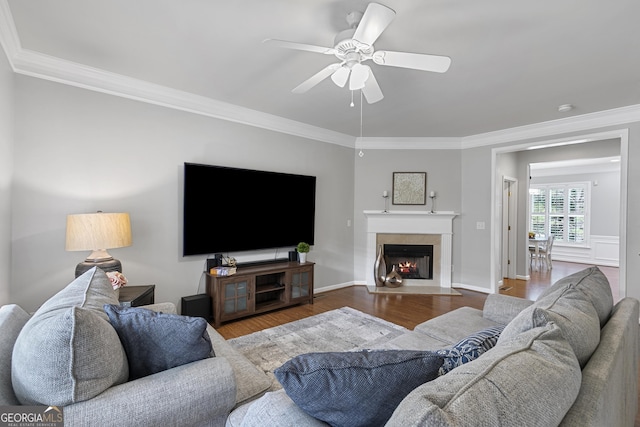 living room featuring wood-type flooring, ceiling fan, and crown molding