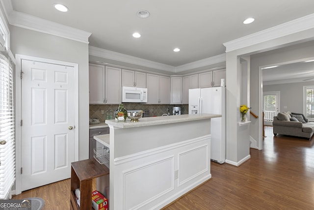 kitchen featuring dark wood-type flooring, gray cabinetry, crown molding, a kitchen island, and white appliances